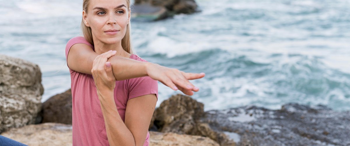 Pretty blonde woman stretching at the beach